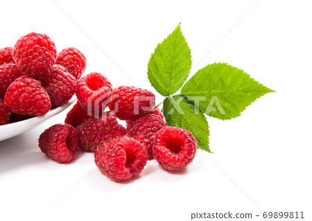 Small plate with ripe raspberries and green leaf isolated on white background. Small plate with ripe raspberries and green leaf isolated on white background. 69899811