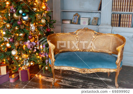 Classic Christmas New Year decorated interior room home library with fireplace. Christmas tree with gold ornament decorations. Modern classical style interior design apartment. Christmas eve at home. Classic Christmas New Year decorated interior room home library with fireplace. Christmas tree with gold ornament decorations. Modern classical style interior design apartment. Christmas eve at home. 69899902