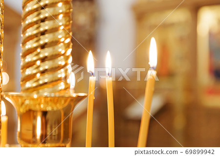Orthodox Church. Christianity. Festive interior decoration with burning candles and icon in traditional Orthodox Church on Easter Eve or Christmas. Religion faith pray symbol. Orthodox Church. Christianity. Festive interior decoration with burning candles and icon in traditional Orthodox Church on Easter Eve or Christmas. Religion faith pray symbol. 69899942