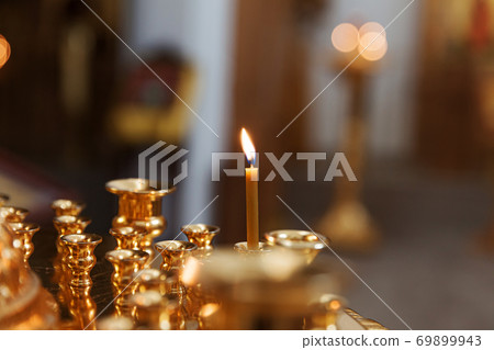 Orthodox Church. Christianity. Festive interior decoration with burning candles and icon in traditional Orthodox Church on Easter Eve or Christmas. Religion faith pray symbol. 69899943