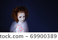 Studio shot of a girl dressed as a zombie , piercing look., halloween background. 69900389