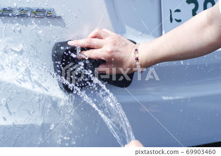 Woman washing a car by hand 69903460