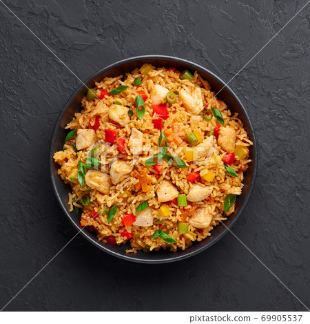 Schezwan Chicken Fried Rice in black bowl at dark slate background. indo-chinese cuisine dish Schezwan Chicken Fried Rice in black bowl at dark slate background. indo-chinese cuisine dish 69905537