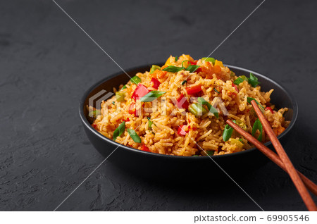 Veg Schezwan Fried Rice in black bowl at dark slate background. indo-chinese cuisine dish Veg Schezwan Fried Rice in black bowl at dark slate background. indo-chinese cuisine dish 69905546