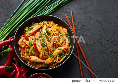 Chicken Schezwan Noodles or Hakka or Chow Mein in black bowl on dark slate table top. 69905558