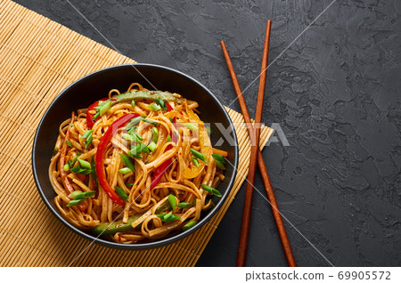 Vegetarian Schezwan Noodles or Vegetable Hakka Noodles or Chow Mein in black bowl on slate table .  69905572