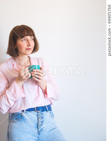 Young woman drinking coffee and smiling 69905768