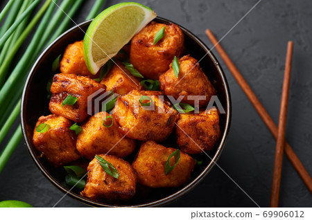 Paneer Manchurian or Paneer 65 in bowl at black concrete background. Paneer Manchurian or Paneer 65 in bowl at black concrete background. 69906012