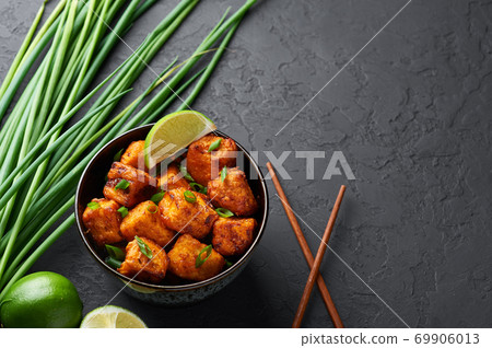 Paneer Manchurian or Paneer 65 in bowl at black concrete background. Paneer Manchurian or Paneer 65 in bowl at black concrete background. 69906013