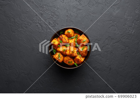 Paneer Manchurian or Paneer 65 in bowl at black concrete background. Paneer Manchurian or Paneer 65 in bowl at black concrete background. 69906023