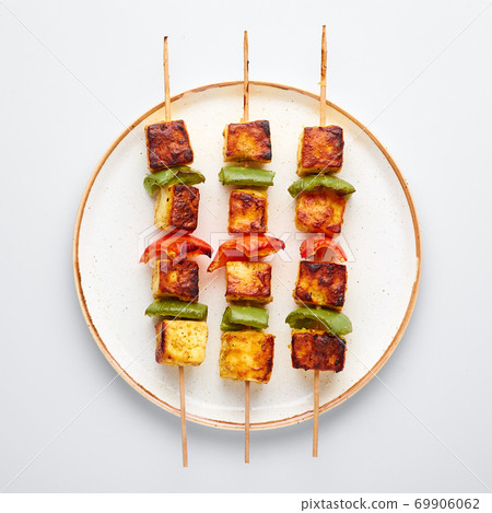 Paneer Tikka at skewers in white plate isolated at white background. Paneer tikka is an indian cuisine dish. Indian Food Paneer Tikka at skewers in white plate isolated at white background. Paneer tikka is an indian cuisine dish. Indian Food 69906062