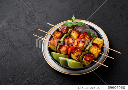 Chicken Tikka at skewers in black bowl on dark slate table top. Indian cuisine dish. Indian food Chicken Tikka at skewers in black bowl on dark slate table top. Indian cuisine dish. Indian food 69906068