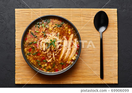Veg Manchow Soup in black bowl on dark slate table top. Vegetarian indo-chinese cuisine dish Veg Manchow Soup in black bowl on dark slate table top. Vegetarian indo-chinese cuisine dish 69906099