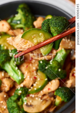 Hunan Chicken in black bowl at dark slate background. Chinese or indo-chinese cuisine takeaway dish Hunan Chicken in black bowl at dark slate background. Chinese or indo-chinese cuisine takeaway dish 69906345