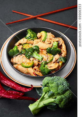 Hunan Chicken in black bowl at dark slate background. Chinese or indo-chinese cuisine takeaway dish Hunan Chicken in black bowl at dark slate background. Chinese or indo-chinese cuisine takeaway dish 69906353