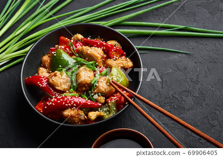 Schezwan Chicken or Dragon Chicken in black bowl at dark slate background. 69906405
