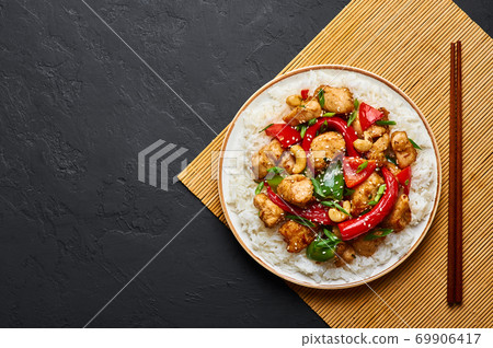 Schezwan Chicken or Dragon Chicken with basmati rice at black slate background. 69906417