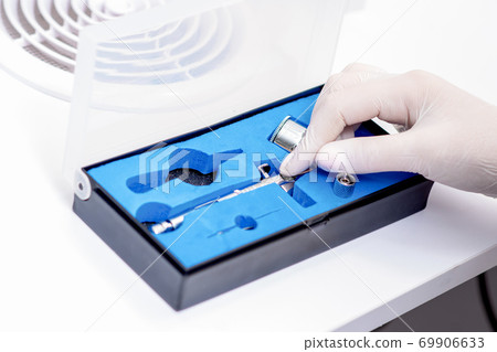 Human hand taking out airbrush tool 69906633