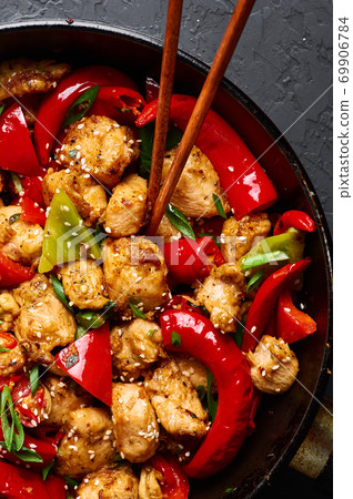 Schezwan Chicken or Dragon Chicken in black bowl at dark slate background. 69906784