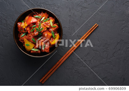 Chicken Manchurian in bowl on black slate table top. Indian chinese food and meal Chicken Manchurian in bowl on black slate table top. Indian chinese food and meal 69906809