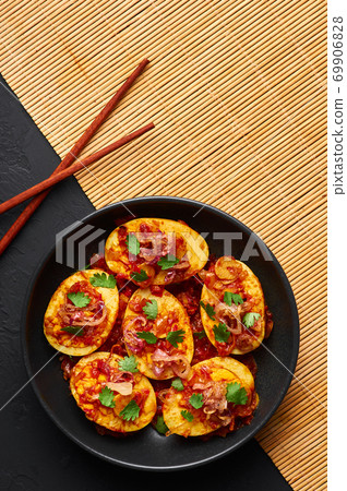 Golden Egg Curry in black bowl on dark slate background. Burmese Egg Curry is Myanmar Cuisine dish Golden Egg Curry in black bowl on dark slate background. Burmese Egg Curry is Myanmar Cuisine dish 69906828