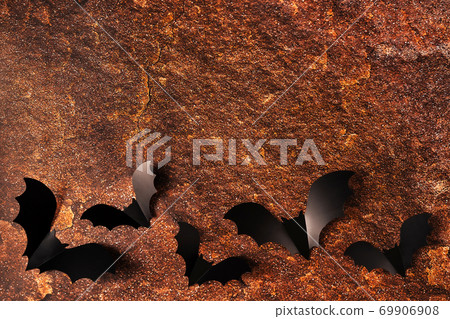Cartoon halloween background black bats on orange stone texture backdrop. Bright holiday backdrop for your design. Dark and moody background. 69906908