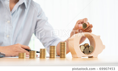 woman hand putting money coin into piggy bank with step of growing stack coins for saving money for future investment concept woman hand putting money coin into piggy bank with step of growing stack coins for saving money for future investment concept 69907453
