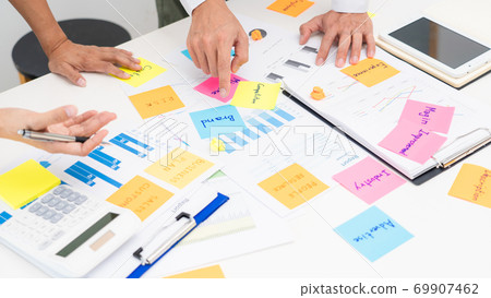 Creative group of business people brainstorming use sticky notes to share idea on glass window or table in office. Creative group of business people brainstorming use sticky notes to share idea on glass window or table in office. 69907462