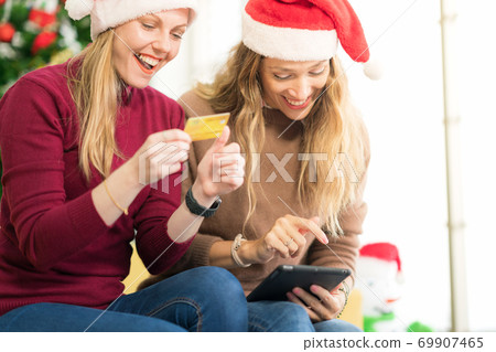 portrait of woman and friend showing a blank credit card in holidays, New Year shopping portrait of woman and friend showing a blank credit card in holidays, New Year shopping 69907465