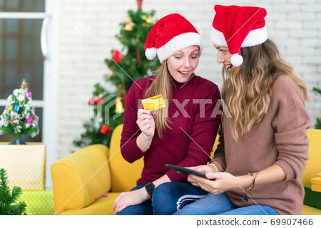 portrait of woman and friend showing a blank credit card in holidays, New Year shopping portrait of woman and friend showing a blank credit card in holidays, New Year shopping 69907466
