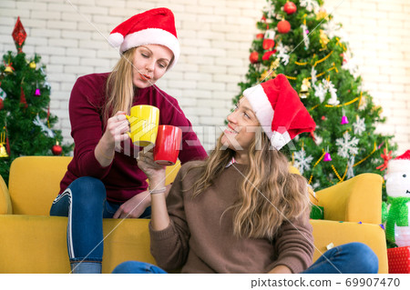 Friends celebrating Christmas or New Year eve and hands hold a color glass 69907470