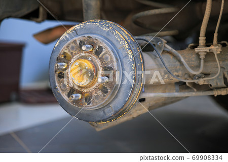 A rear hub of the car after removing a tire and wheel, maintaining a brake and wheel system, car jack-up for change a car wheel, Close-up shot A rear hub of the car after removing a tire and wheel, maintaining a brake and wheel system, car jack-up for change a car wheel, Close-up shot 69908334