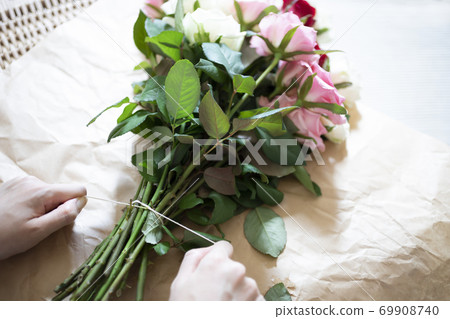 女人的手綁一束玫瑰花用繩子 69908740
