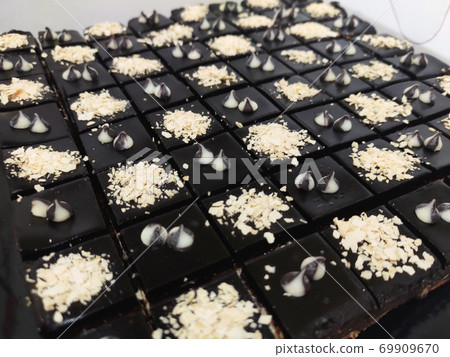 Selected focused on the chocolate & cheese cake. Rectangular in shape. Has been cut into small cubes to make it easier to eat. Selected focused on the chocolate & cheese cake. Rectangular in shape. Has been cut into small cubes to make it easier to eat. 69909670