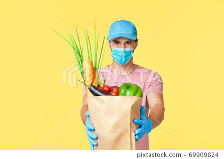 Delivery man delivering grocery bag wearing face mask and gloves