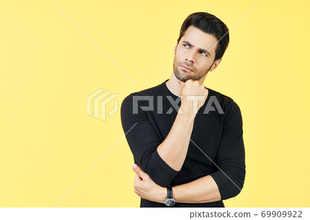 Young thoughtful man thinking and looking aside on copy space isolated on yellow background 69909922
