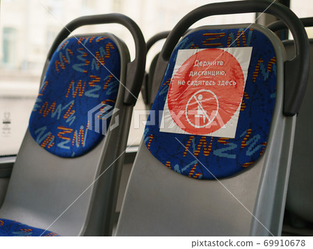 Interior of empty public blue bus Seats are free. People stay at home during quarantine. Coronavirus Pandemic lifestyle. Transl. Keep the distance. Do not sit here. Interior of empty public blue bus Seats are free. People stay at home during quarantine. Coronavirus Pandemic lifestyle. Transl. Keep the distance. Do not sit here. 69910678