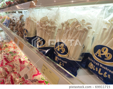 SEREMBAN, MALAYSIA -AUGUST 16, 2020: Various types of mushrooms in a transparent food package. Placed on a cooling rack and displayed to customers. SEREMBAN, MALAYSIA -AUGUST 16, 2020: Various types of mushrooms in a transparent food package. Placed on a cooling rack and displayed to customers. 69911715