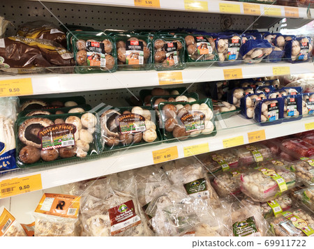 SEREMBAN, MALAYSIA -AUGUST 16, 2020: Various types of mushrooms in a transparent food package. Placed on a cooling rack and displayed to customers. SEREMBAN, MALAYSIA -AUGUST 16, 2020: Various types of mushrooms in a transparent food package. Placed on a cooling rack and displayed to customers. 69911722