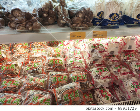 SEREMBAN, MALAYSIA -AUGUST 16, 2020: Various types of mushrooms in a transparent food package. Placed on a cooling rack and displayed to customers. 69911729