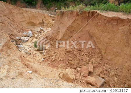Erosion at ground and slopes is caused by rainfall. The soil structure is weak and there is a landslide. Safety measure has been taken in some area. 69913137