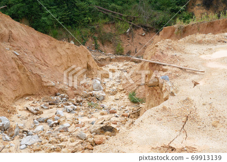 Erosion at ground and slopes is caused by rainfall. The soil structure is weak and there is a landslide. Safety measure has been taken in some area. 69913139