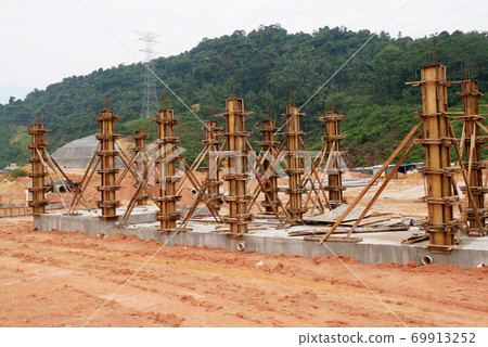 KUALA LUMPUR, MALAYSIA -SEPTEMBER 19, 2020: Column timber formwork and reinforcement bar at the construction site. Installed by construction workers. The structure supported by temporary wood support. 69913252