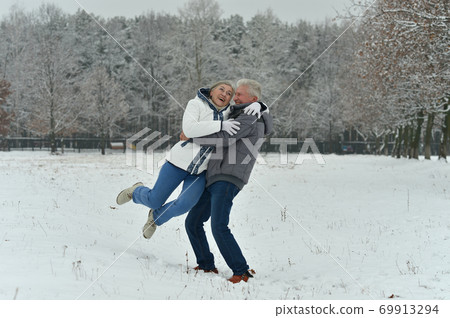 Happy senior couple hugging at snowy winter park 69913294