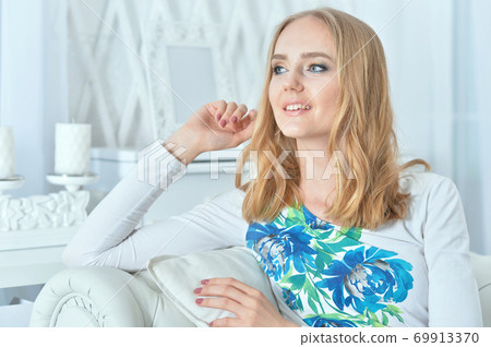 Portrait of beautiful young woman daydreaming at home Portrait of beautiful young woman daydreaming at home 69913370