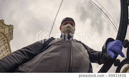 Man wearing protective mask outdoors. Coronavirus pandemic time. Man wearing protective mask outdoors. Coronavirus pandemic time. 69913438