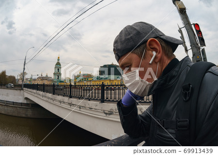 Man wearing protective mask outdoors. Coronavirus pandemic time. 69913439