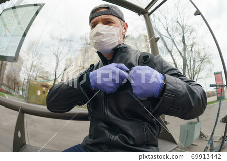 Man wearing protective mask outdoors. Coronavirus pandemic time. Man wearing protective mask outdoors. Coronavirus pandemic time. 69913442