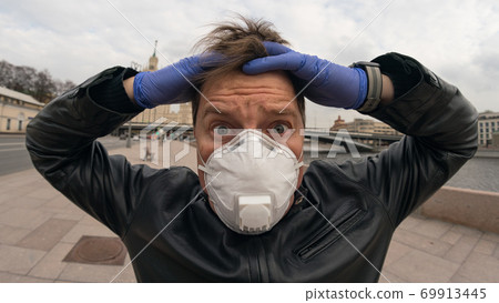 Man wearing protective mask outdoors. Coronavirus pandemic time. Man wearing protective mask outdoors. Coronavirus pandemic time. 69913445