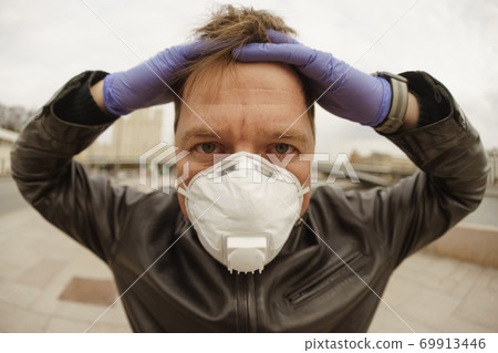 Man wearing protective mask outdoors. Coronavirus pandemic time. 69913446